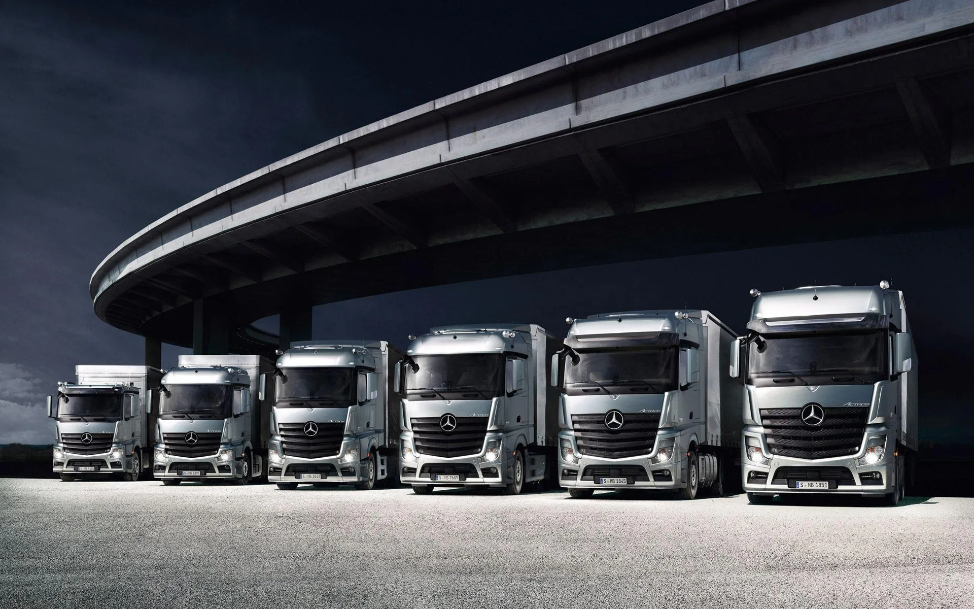 An image of Mercedes Benz trucks in a darkly lit environment